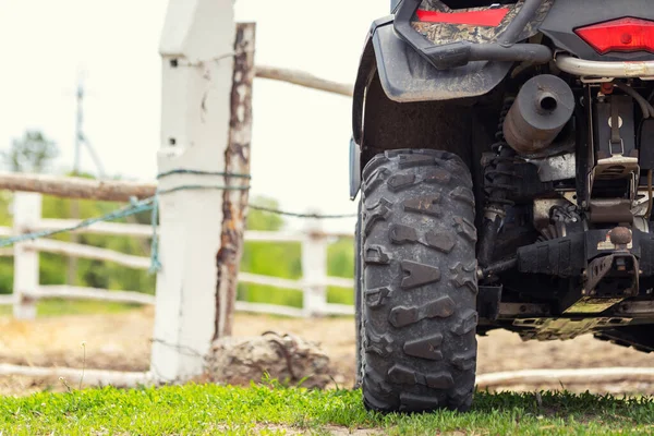 Quad-Fahrzeug steht in der Nähe von Holzzaun auf Bauernhof oder Pferdestall. Rückansicht eines allradgetriebenen Motorrads am Bauernhof. Landmaschinerie — Stockfoto