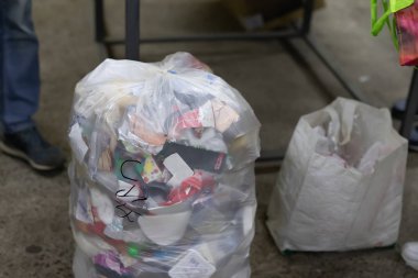 Geri dönüşüm toplama noktasında geri dönüşümsüz çöplerle dolu tam ev yapımı plastik çöp torbası. Çevre kirliliği kavramı