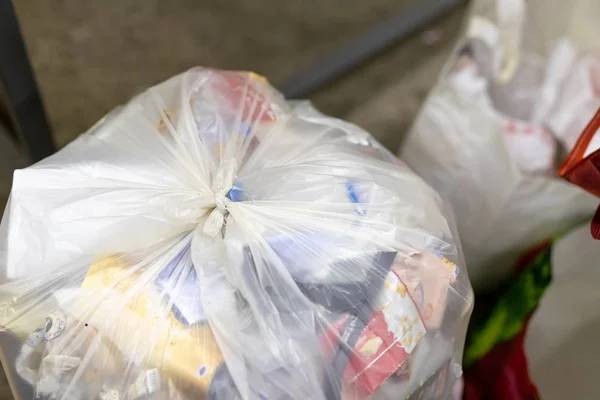 Primer plano atado bolsa de residuos de plástico doméstica llena de basura no reciclable en el punto de recogida de aceptación de reciclaje. Concepto de contaminación ambiental. Preparado para la combustión en incinerador — Foto de Stock