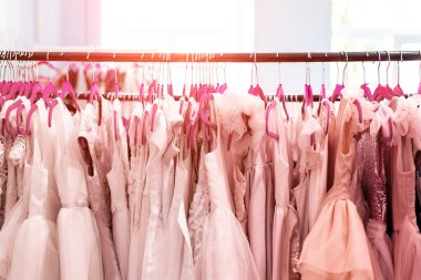 İçinde bir sürü güzel tatil elbisesi olan raflar kadın moda galerisinde askılarda asılı. Çocuk giyim stüdyosu doğum günü partisi ya da fotoğraf çekimi için stüdyo kiralıyor. Mercan pembesi tonlu
