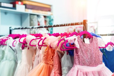 İçinde bir sürü güzel tatil elbisesi olan raflar kadın moda galerisinde askılarda asılı. Çocuk giyim stüdyosu doğum günü partisi ya da fotoğraf çekimi için stüdyo kiralıyor. Parlak güneş günü