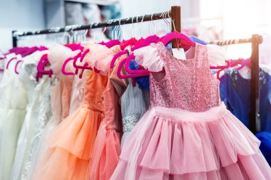 İçinde bir sürü güzel tatil elbisesi olan raflar kadın moda galerisinde askılarda asılı. Çocuk giyim stüdyosu doğum günü partisi ya da fotoğraf çekimi için stüdyo kiralıyor. Parlak güneş günü
