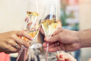 Kadın ve erkeklerin el çırptığı beyaz şampanya kadehleri ya da partide ya da dışarıda kutlama etkinliğinde Prosecco 'nun yakın plan detayları. Eğlenen insanlar, kafeteryada alkollü tost içmekten zevk alırlar..
