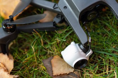 Kaza sonrası kara kuadkopter insansız hava aracı kaza yaptıktan sonra yeşil çimlerin üzerinde yatıyordu. Güçlü rüzgar paraziti nedeniyle uzaktan kumanda arızası. Çatlak kamera titremesi ve plastik bacaklar..