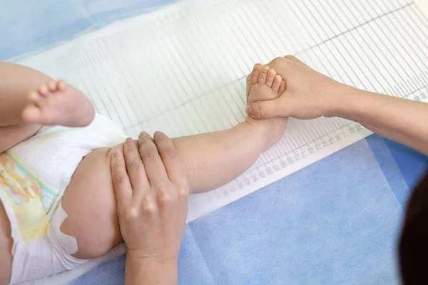 儿科专家在检查期间测量婴儿的身高 医生或护士牵着孩子的腿测量人的长度 儿童保健和预防 — 图库照片