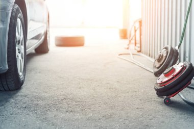 Araba tekerleği tamir atölyesi. Atölyede mevsimlik lastik değişimi. Araç lastiği tamiri, teftiş ve bakım. Şişirilebilir hava basınçlı otomotiv garajı. Kopyalama metni.