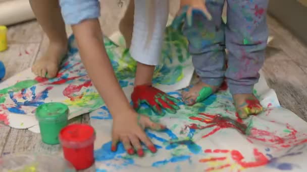 Adorável bonito caucasiano pequenos irmãos loiros crianças gostam de se divertir em conjunto com pincel de pintura mãe e palma em casa dentro de casa. Alegres crianças felizes sorrindo desenho obra-prima arte imagem — Vídeo de Stock