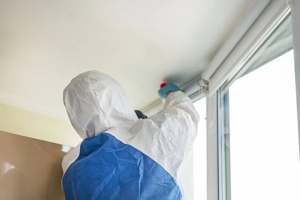 Korunaklı biyolojik giysi ve gaz maskesi takan adam koronavirüs salgını tehlikesi ve uyarısı nedeniyle. İşçiler dezenfeksiyon, haşere kontrolü ve küf temizleme ve havalandırma yapıyor. — Stok fotoğraf