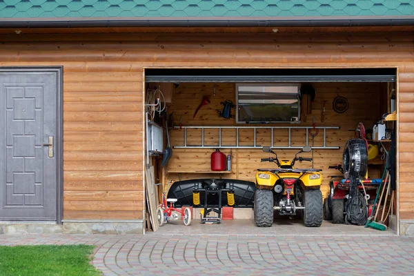 ファサードフロントビューオープンドアAtvクワッドバイク駐車場自宅の私道の裏庭や芝生のパスで木製の側面を持つ厄介なガレージの建物 道具や設備のための家の倉庫 ガレージセール — ストック写真