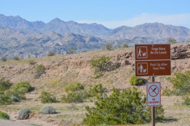 Köpekler tasmalı ve evcil hayvan tabelasının arkasını toplamalı. Mohave County, Arizona 'daki Mead Gölü Ulusal Rekreasyon Bölgesi' nde havai fişek işareti yok.