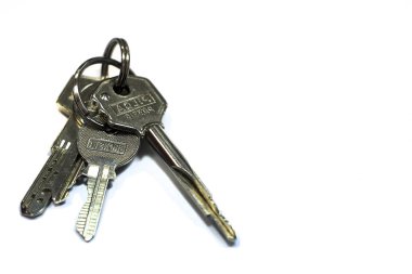 Beyaz bir arka plan üzerinde anotlanmış metal anahtarlar