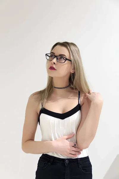 Schöne Blondine mit Brille auf hellem Hintergrund — Stockfoto