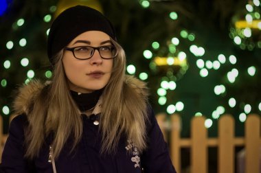 Güzel bir kız bardaklarda bir yılbaşı ağacı arka plan üzerinde duruyor