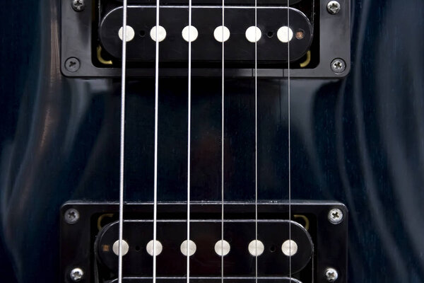 Detail of six-string electric guitar closeup, selective focus.Processed with vintage style. pickups of an electric guitar close-up in a low key, copy paste texture background.