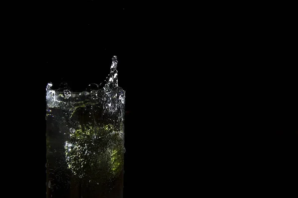 Green broccoli falling in water on white with air bubbles Broccoli in water, freezing time, splashing water