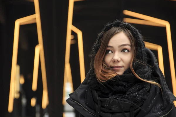 Young fashion blonde girl wearing long black scarf on the background of the futuristic building — Stock Photo, Image