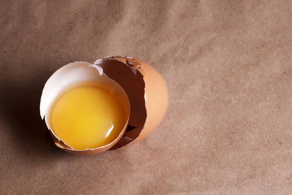 A egg yolk in cracked egg shell.