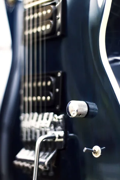 Detalle de una guitarra eléctrica negra low key con luz suave y profundidad de campo —  Fotos de Stock