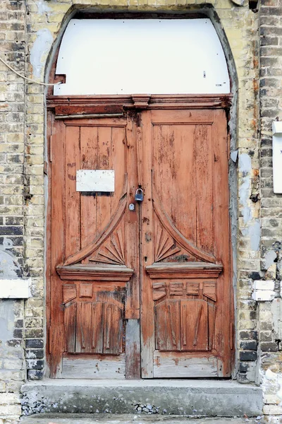 Starożytne drewniane drzwi w starej kamiennej ścianie zamku. — Zdjęcie stockowe