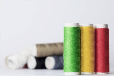 Dikiş aksesuarları beyaz bir arka plan üzerinde yalan. Konu çok renkli bobinleri.