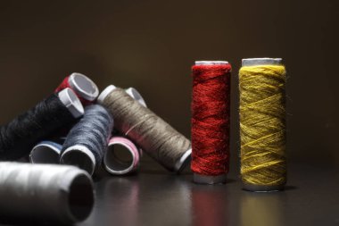 Arka plan iş parçacığı ile renkli bobinleri bir sürü ile. Bobin diğer üç satır dizilir. Sarma düzensiz. Çok renkli konu.