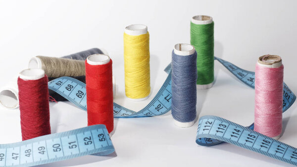sewing kit, needles, thread and measuring tape on a white background