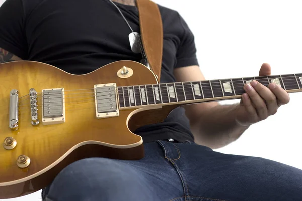 Uomo con chitarra elettrica seduto isolato su bianco — Foto Stock