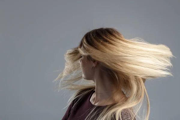 Una chica con el pelo muy bien arreglado se divierte en la cámara y menea la cabeza, un buen estado de ánimo, fotos abstractas de cabello hermoso — Foto de Stock