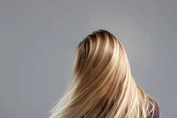 Una chica con el pelo muy bien arreglado se divierte en la cámara y menea la cabeza, un buen estado de ánimo, fotos abstractas de cabello hermoso —  Fotos de Stock