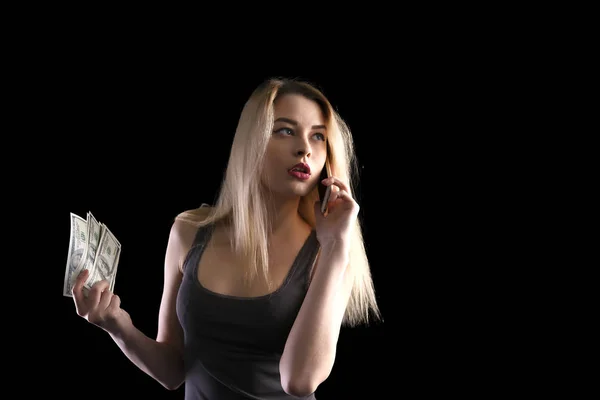 Successful woman speaks on the phone and keeps hundred dollar bills on a black background — Stock Photo, Image