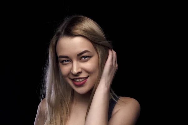 Mulher com sorriso tocando a cabeça. Maquiagem lábios vermelhos, cabelo morena, pele limpa, olhos azuis modelo menina. Fundo preto — Fotografia de Stock