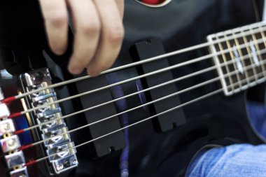 Sahne Alanı'nda bas gitar çalmaya müzisyen parmakları yakın çekim