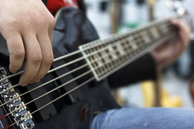 Sahne Alanı'nda bas gitar çalmaya müzisyen parmakları yakın çekim