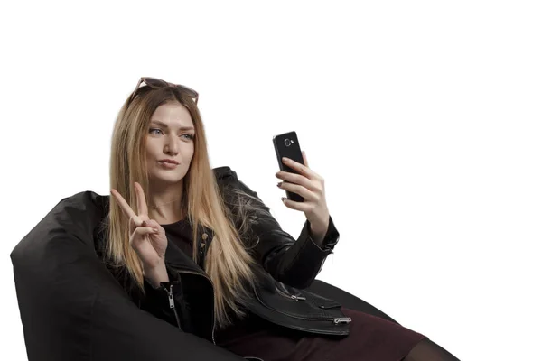 Meisje doet zelf telefoon op een witte achtergrond — Stockfoto