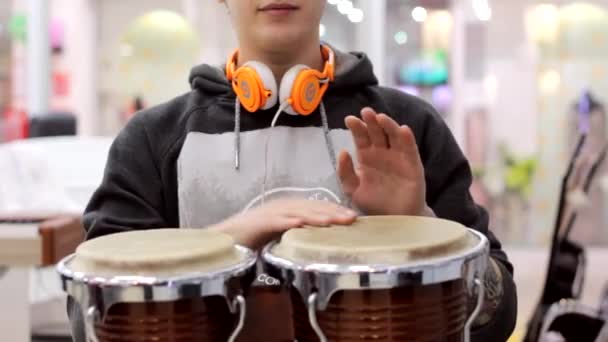 Un hombre toca instrumentos de percusión en una tienda de música — Vídeo de stock