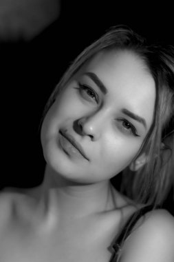 Kazaklı siyah arka plan üzerine siyah beyaz portre genç ve güzel kadın. Düşük anahtar. Kapalı.