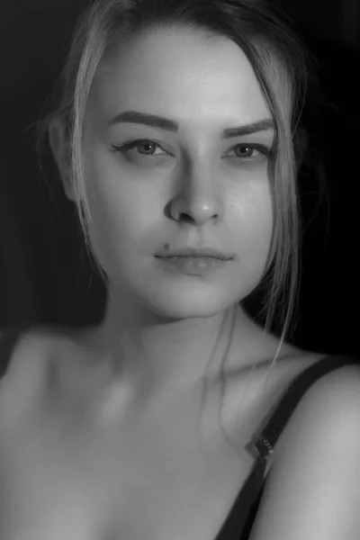 Černobílý portrét hezká mladá žena v svetru na černém pozadí. Nízký klíč. Vnitřní. — Stock fotografie