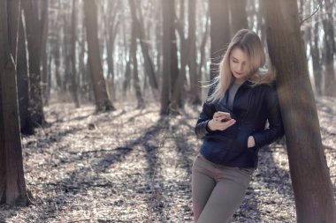 Searhing için cep telefonunuzun ve haber okumak genç kadın