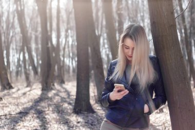Searhing için cep telefonunuzun ve haber okumak genç kadın