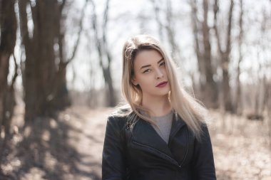 Güzel esmer bir kızın açık hava portresi. Güneşli yaz ya da bahar gününde şehrin arka planında mutlu gülümseyen bir kadın. Altın saat içinde yakın plan bir portre. Seçici odak.