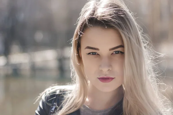 Ao ar livre retrato de bela jovem morena. Mulher sorrindo feliz no verão ensolarado ou dia de primavera fora no fundo da cidade. Retrato de close-up em uma hora dourada. Foco seletivo. — Fotografia de Stock