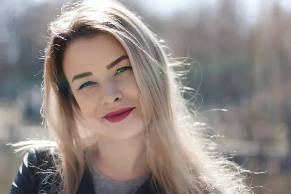 Ao ar livre retrato de bela jovem morena. Mulher sorrindo feliz no verão ensolarado ou dia de primavera fora no fundo da cidade. Retrato de close-up em uma hora dourada. Foco seletivo. — Fotografia de Stock