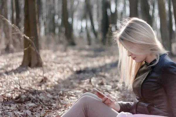 Searhing için cep telefonunuzun ve haber okumak genç kadın