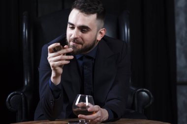 Reklam veya metin için bir yer ile pahalı bir karanlık iç arka plan üzerinde takım elbiseli bir genç adam.