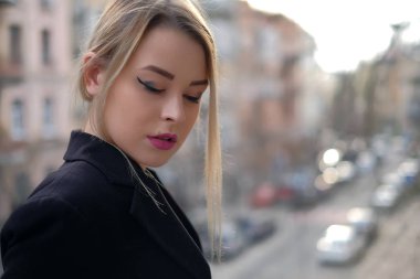 Siyah bir genç bir kadın portresi uygun batan güneşin ışınları bulanık bir şehirde çerçevede bir yakın çekim.