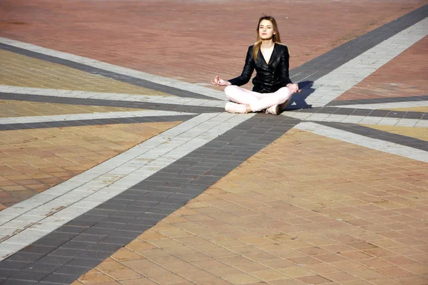 Beautiful young woman meditating and exercise yoga in lotus position at street at beautiful sunny day — Stock Photo, Image