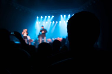 Seyirci sanatçılarla sahne izliyor.