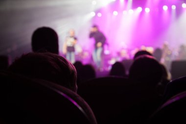 Seyirci sanatçılarla sahne izliyor.