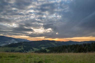 Gün batımını arka plan üzerinde dağ silsilesi