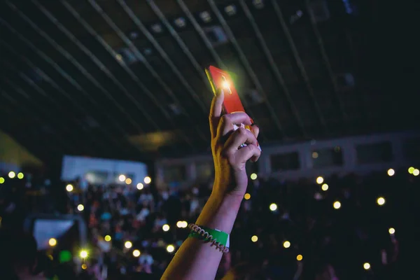 Konserde kadın eli ile akıllı telefon..